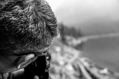 Close-up of man photographing through camera