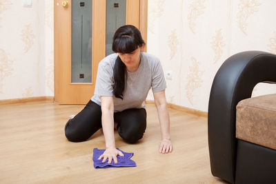 Woman wiping hardwood floor at home