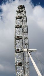 Low angle view of ferris wheel against cloudy sky