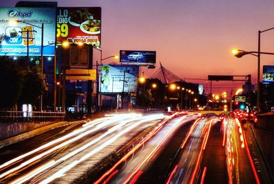 Light trails on road during sunset