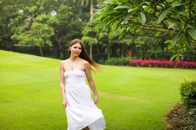 Full length of a smiling young woman standing outdoors