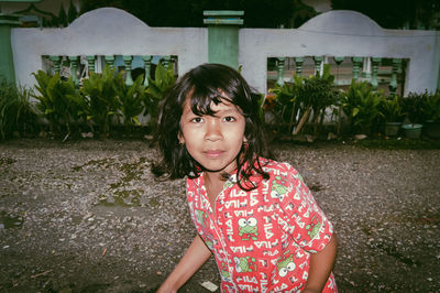 Portrait of girl standing against plants