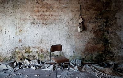 Abandoned chairs against wall