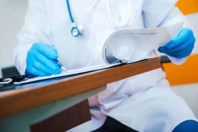 Midsection of male doctor working at table