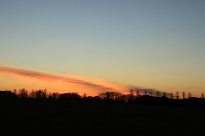 Silhouette landscape against clear sky during sunset