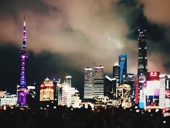 Illuminated buildings in city against sky at night
