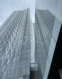 Low angle view of modern glass building against sky