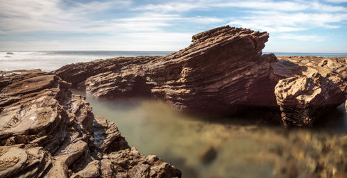 Rock formations in sea against sky