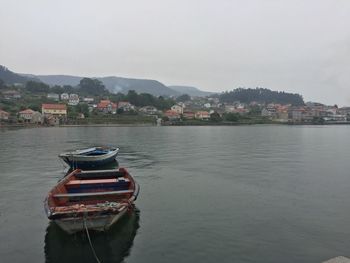 Boats in river with buildings in background