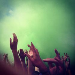 Cropped image of hands raised in green powder paint