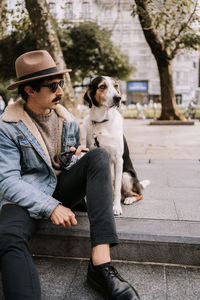 Full length of woman with dog sitting outdoors