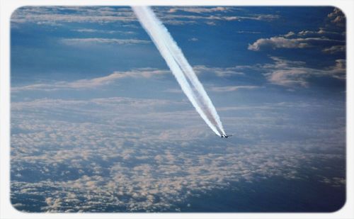 Cropped image of airplane flying over clouds