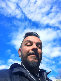 Low angle portrait of man against sky