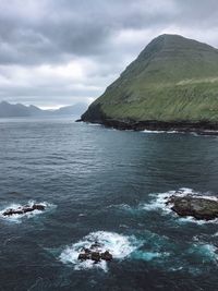 Scenic view of sea and mountains against sky