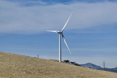 Windmill on field against sky