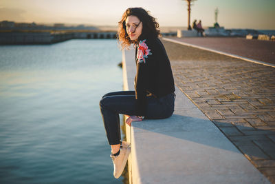 Portrait of woman sitting against sky during sunset