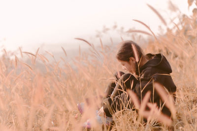 Woman with plants on field against sky