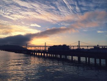 Bridge over river at sunset