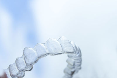 Close-up of dental prosthetic equipment against sky