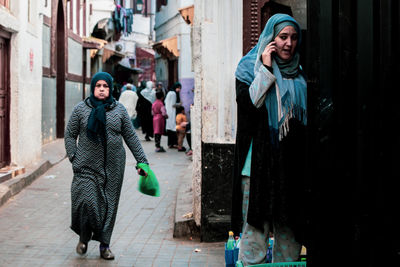 Full length of woman standing on footpath in city