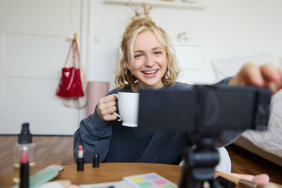 Portrait of smiling young woman using mobile phone