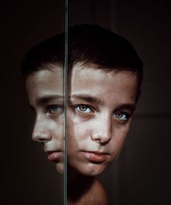 Close-up portrait of boy peeking by mirror