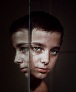 Close-up portrait of young man against black background