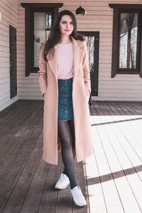 Portrait of beautiful young woman standing on porch