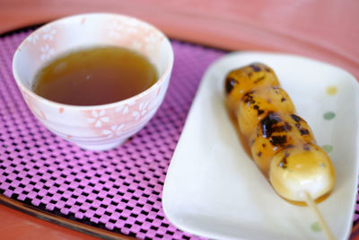 Close-up of tea cup with food in tray on table