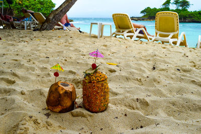 Lounge chairs and sand on beach against sky