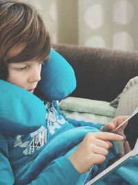 Girl using digital tablet on sofa at home