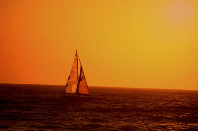 Silhouette of boat in sea at sunset
