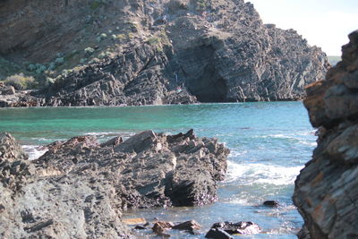 Rocks by sea against sky