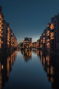 Illuminated cityscape against sky at night