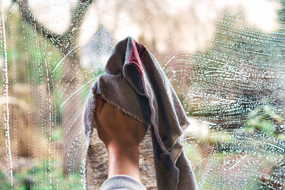 Low section of person standing on wet glass