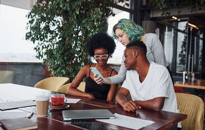 Group of multi ethnic people with alternative girl with green hair is working together