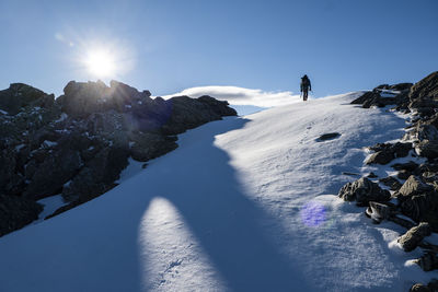 Figure hiking up a snow slope in the alpine mountains of new zealand