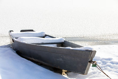 Boat moored on shore during winter