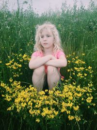 Portrait of woman with yellow flowers on field