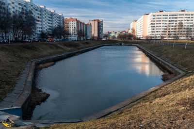 River amidst buildings in city against sky