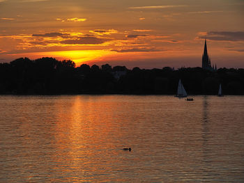 Scenic view of lake against orange sky