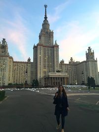 Smiling woman standing on street against lomonosov moscow state university