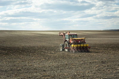 Tractor on agricultural field against sky