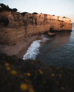 Rock formations on beach against sky