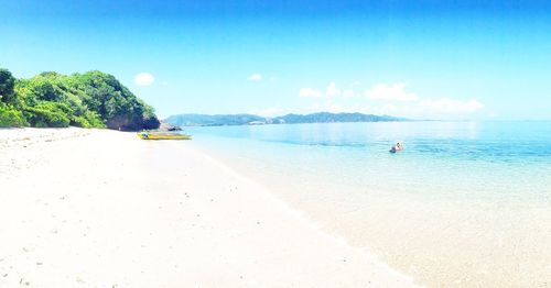 Scenic view of beach against blue sky