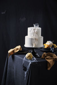 Close-up of cake on table against black background