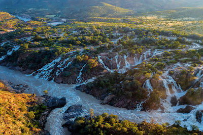 High angle view of river and waterfall amidst trees