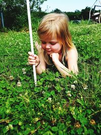 Girl holding plant on field