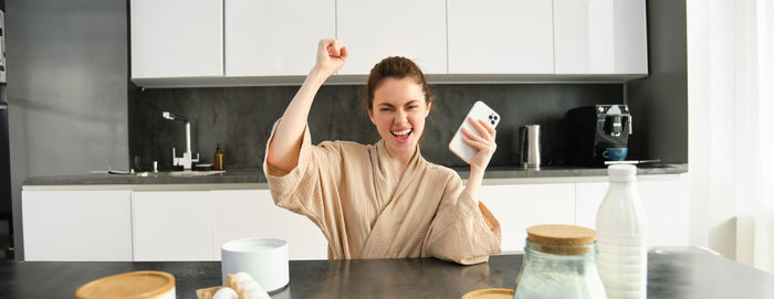 Side view of young woman drinking coffee at home