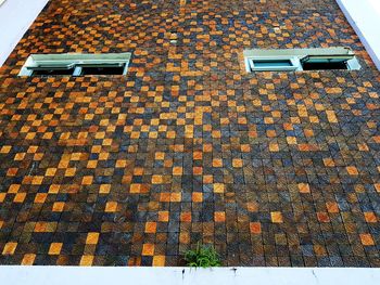 High angle view of dry leaves on footpath against building